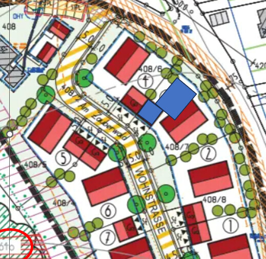 Übersichtlicher Lageplan: rote Gebäude, grüne Bäume, blaue Bauteile, Straßenverlauf.