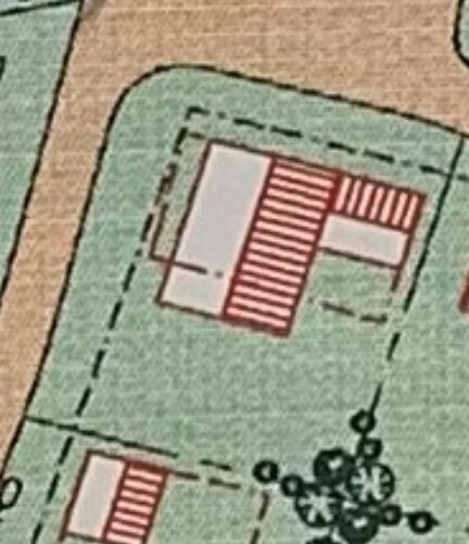 Grundstücksplan: grüne Fläche, rotes gestreiftes Gebäude, Grenzlinien, Baumgruppe.