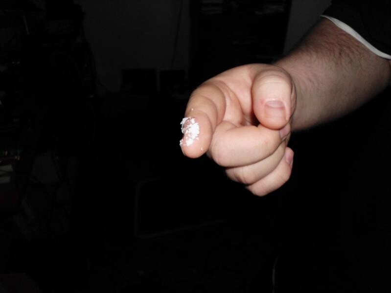 Nahaufnahme einer Hand mit weißem Pulver am Finger