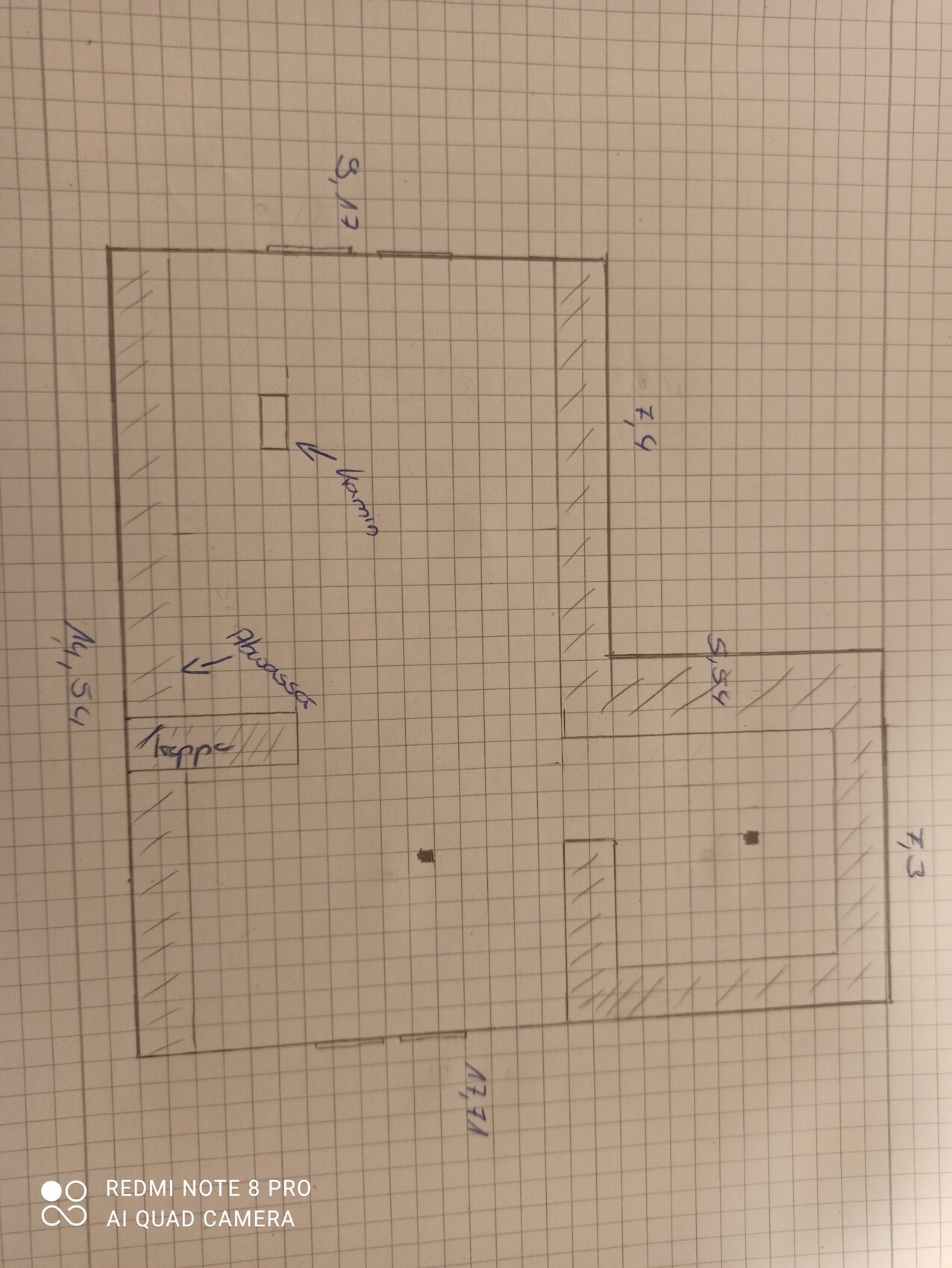 Handgezeichneter Grundriss auf kariertem Papier mit mehreren beschrifteten Räumen.