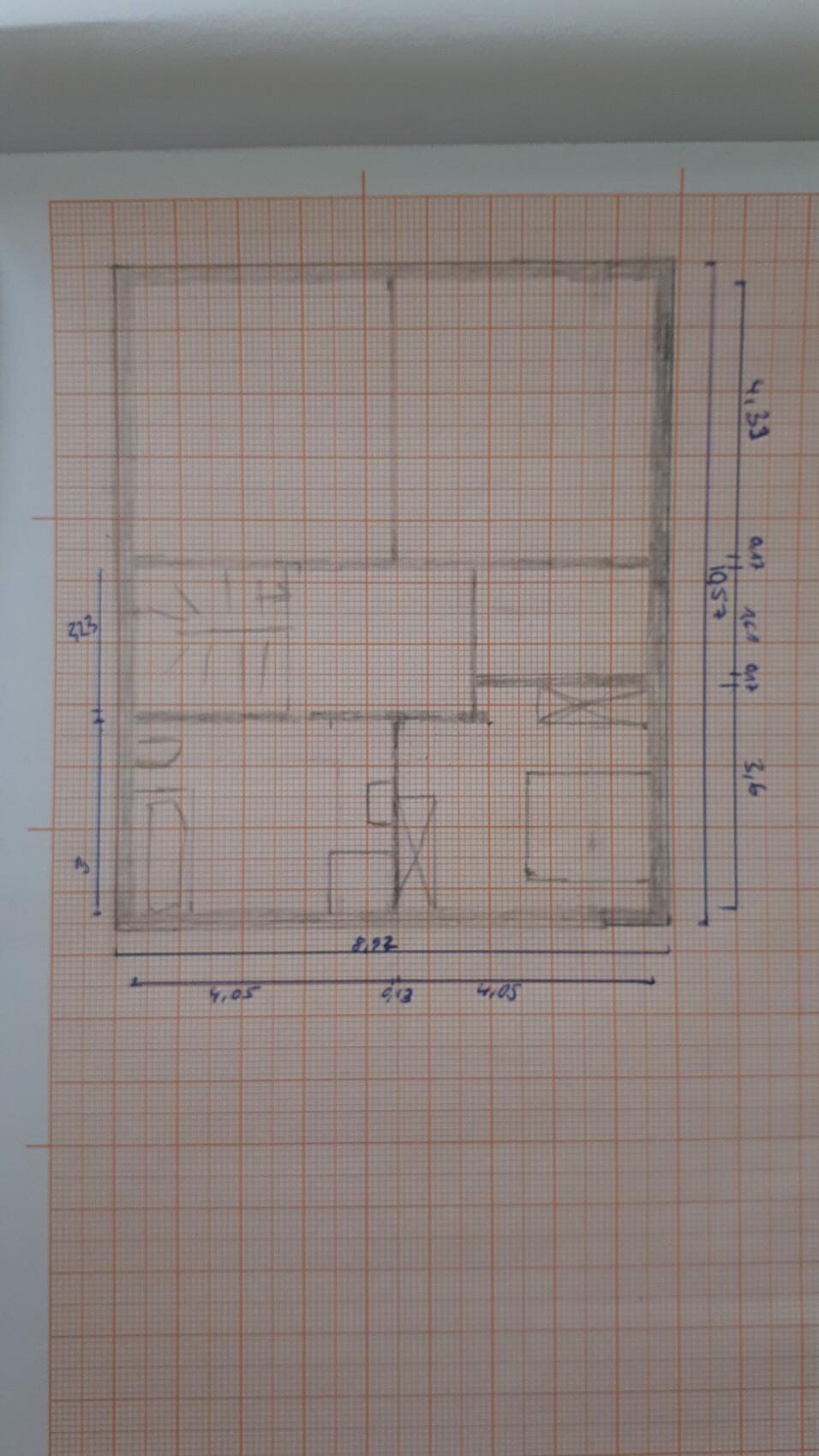 Handgezeichnete Grundriss-Skizze eines Innenraums auf kariertem Papier mit Abmessungsangaben.