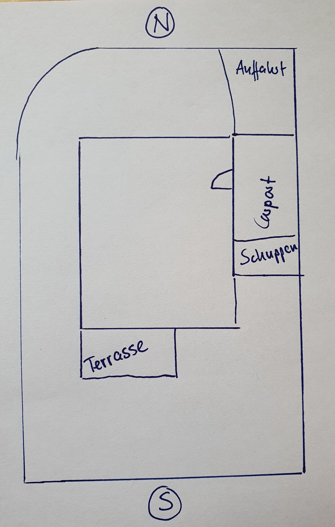 Grundriss eines Gebäudes: zentraler Innenraum, Terrasse links unten, Aufgang und Schuppen rechts.
