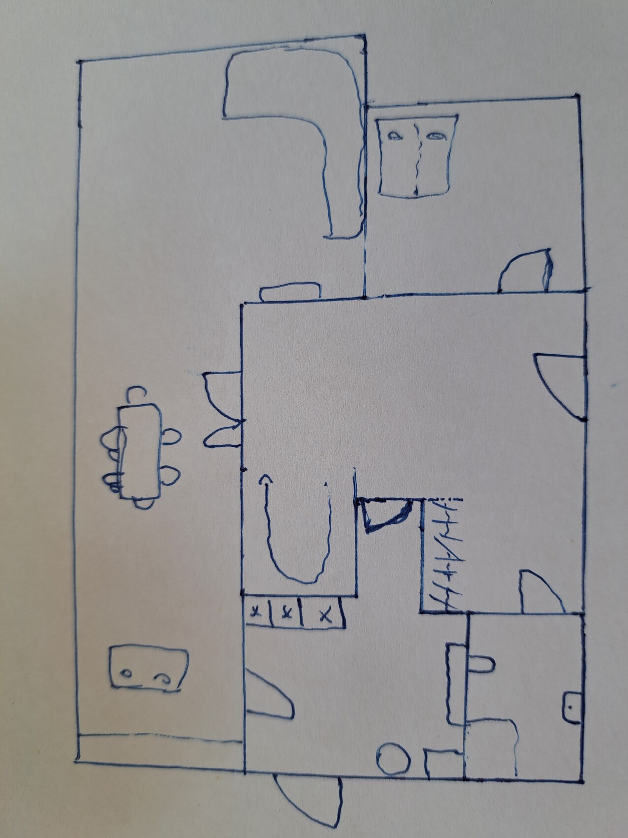 Handgezeichneter Grundriss eines Wohn- und Essbereichs mit Küche, Tisch und Türen.