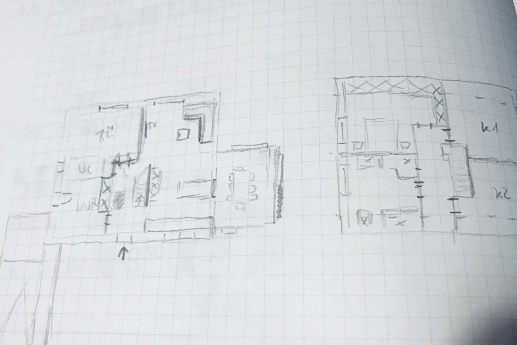 Skizze eines zweigeteilten Grundrisses auf kariertem Papier mit mehreren Zimmern, Türen und Treppen.