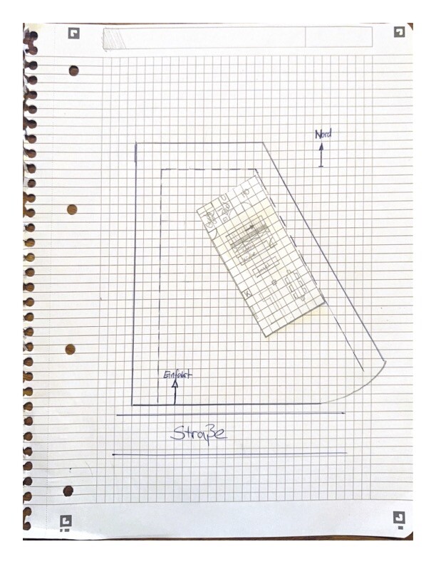 Handgezeichnete Grundstücksskizze auf Karopapier: äußere Grenze, Gebäude, Nordpfeil, Eingang, Straße.