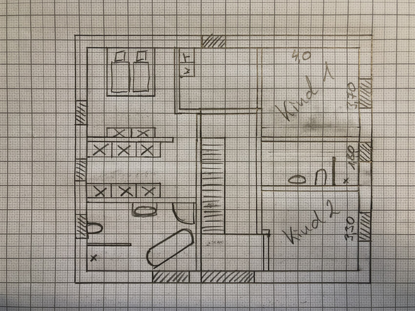 Handskizze eines Wohnungsgrundrisses: Schlafzimmer mit zwei Betten, Küche, Bad, Flur und Treppe.