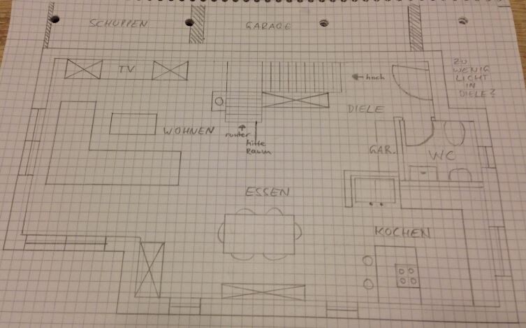 Handgezeichneter Grundriss eines Hauses: Räume Wohnen, Essen, Kochen, Diele, WC, Garage.