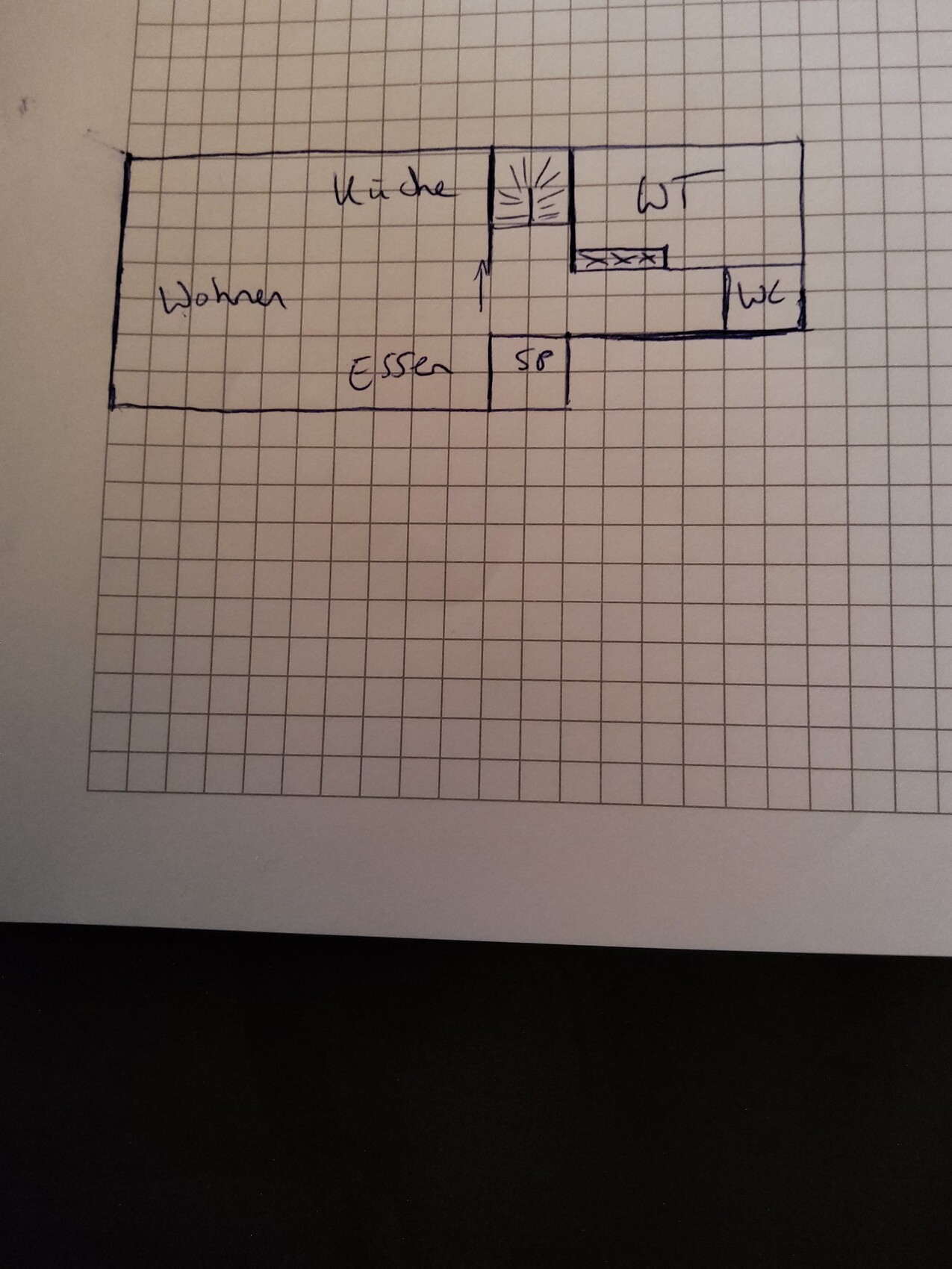 Skizzenhafter Grundriss eines Wohnhauses mit Küche, Wohnen, Essen, WC und Treppenaufgang.