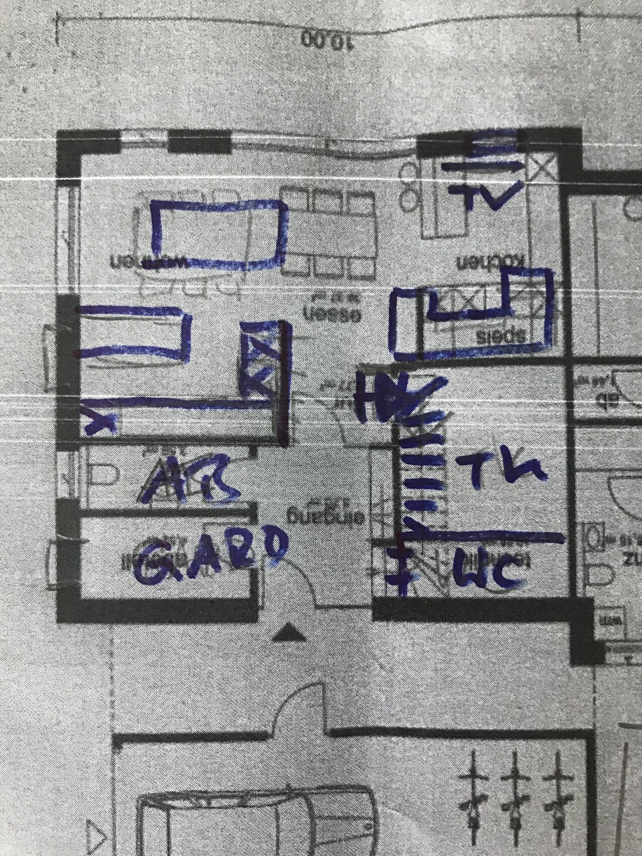 Grundriss eines Hauses mit blauer Handschrift, markierte Räume wie Wohnzimmer, Flur, Küche, WC, Garderobe.