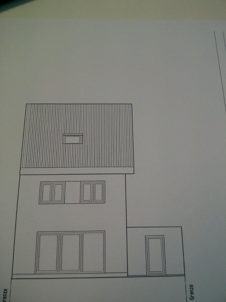 Außenansicht eines modernen zweistöckigen Hauses mit großen Fenstern und Anbau.