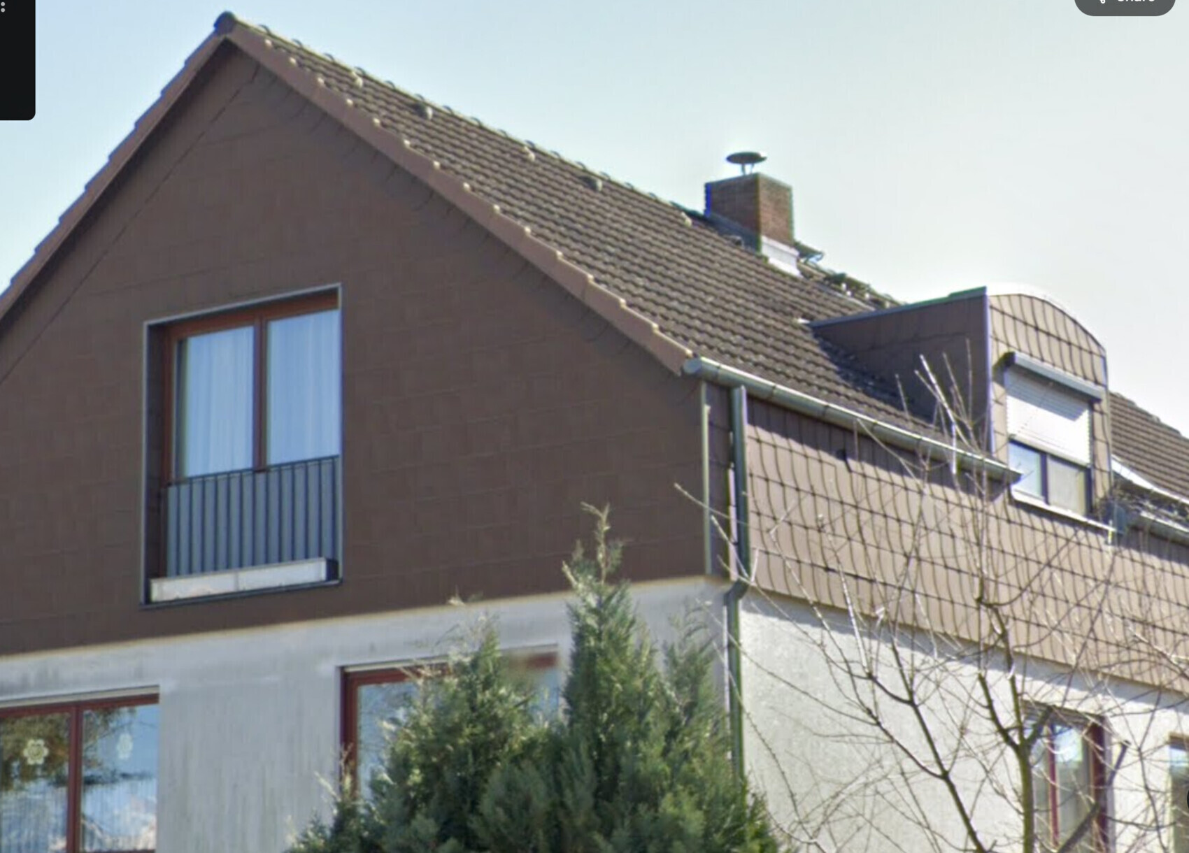 Außenansicht eines modernen Wohnhauses mit brauner Fassade und Dachziegeln