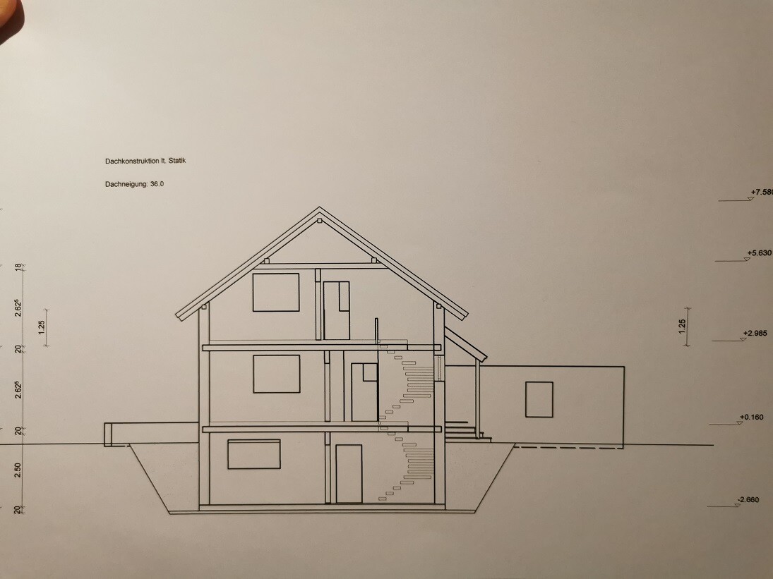 Schnitt durch ein mehrstöckiges Gebäude mit geneigtem Dach, Treppenhaus und seitlichem Anbau.
