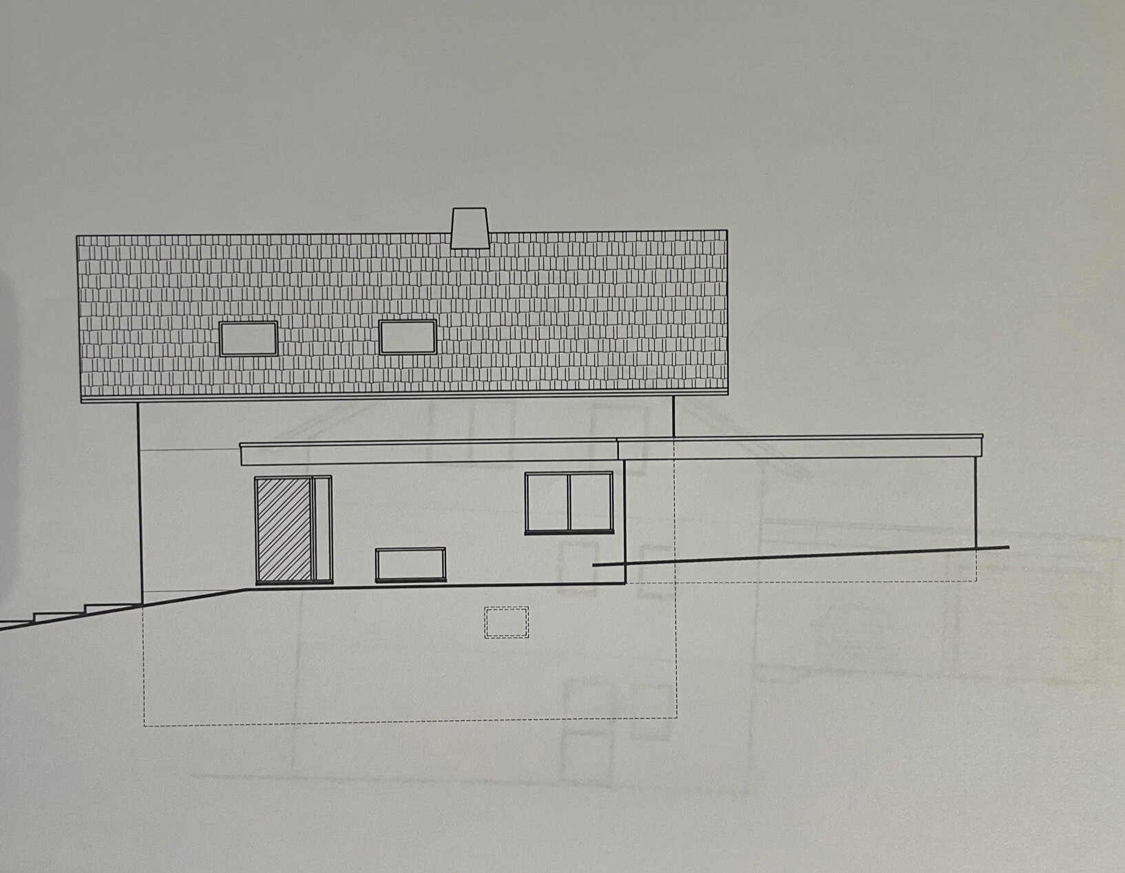 Architektenzeichnung eines Wohnhauses mit Satteldach, Dachfenstern, Eingangstür und seitlichem Flachdach-Anbau.