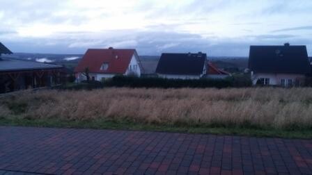 Straßenansicht von Wohnhäusern in einer Siedlung mit Gras im Vordergrund
