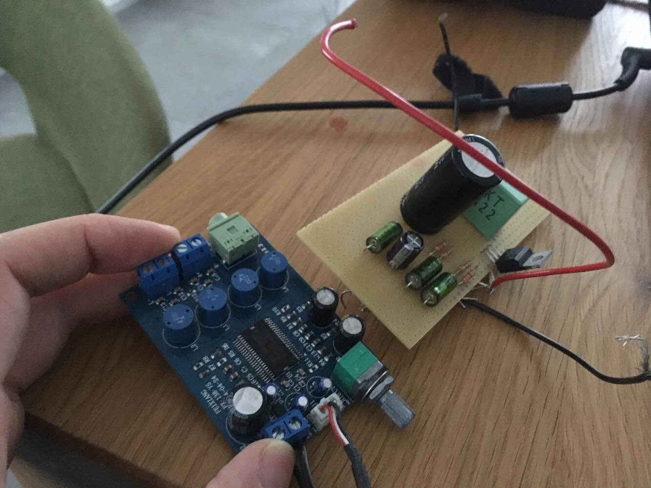 Elektronische Baugruppen mit Kondensatoren und Kabeln auf Holztisch