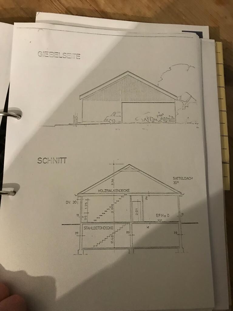 Giebelseite eines Hauses mit Satteldach; darunter Gebäudeschnitt mit Treppen.