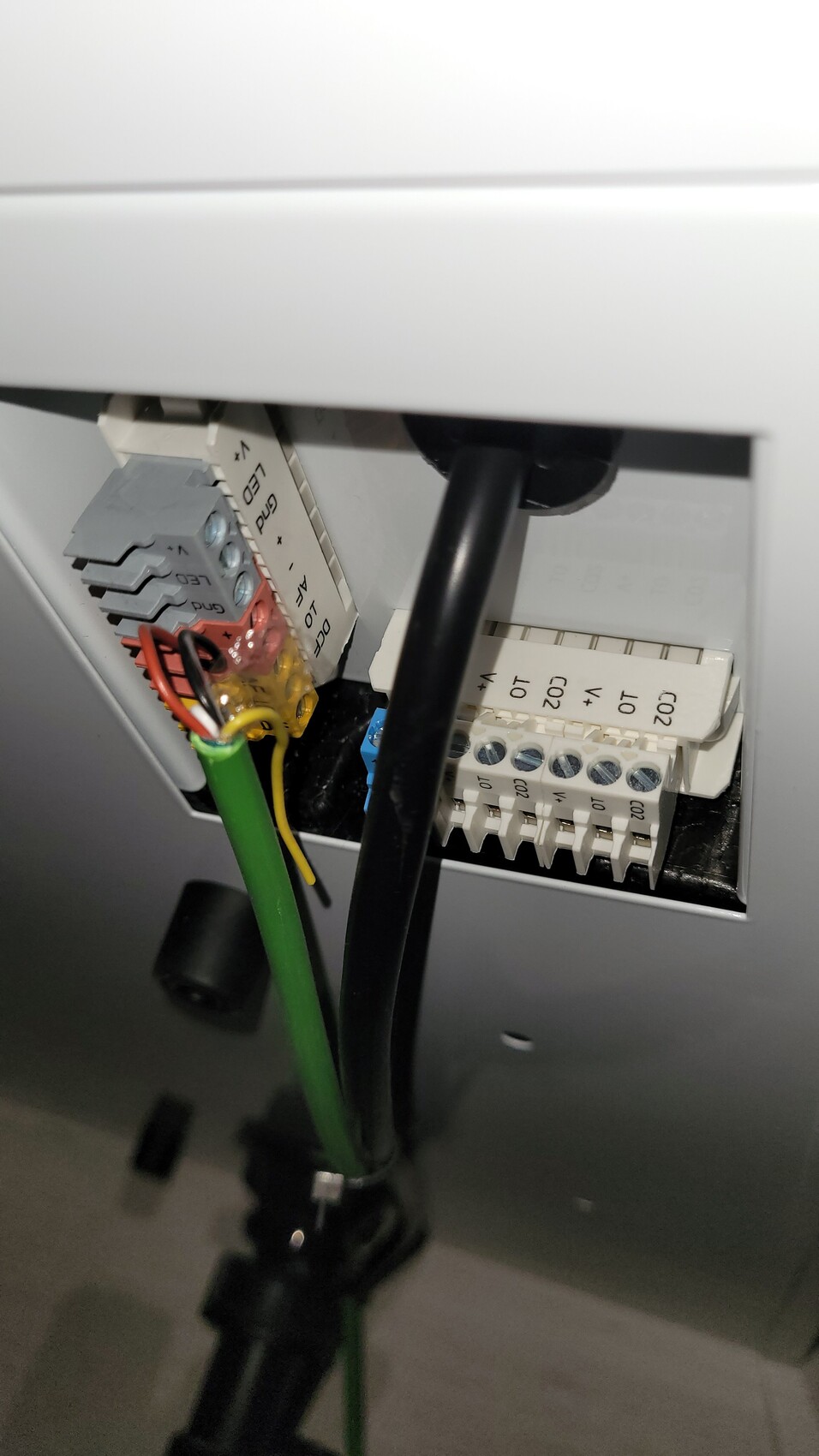 Nahaufnahme von elektrischen Anschlussklemmen mit Drahtverbindungen im Gehäuse.