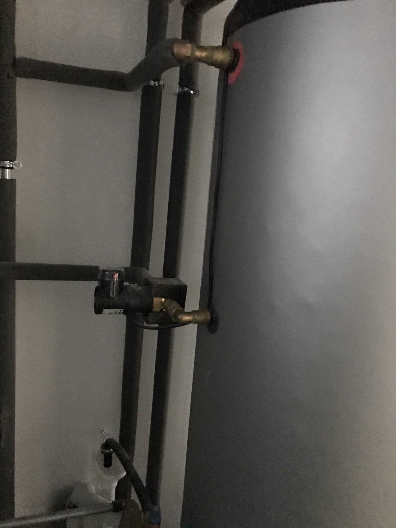 Heizungsraum mit Warmwasserboiler, Zirkulationspumpe und Rohrleitungen.