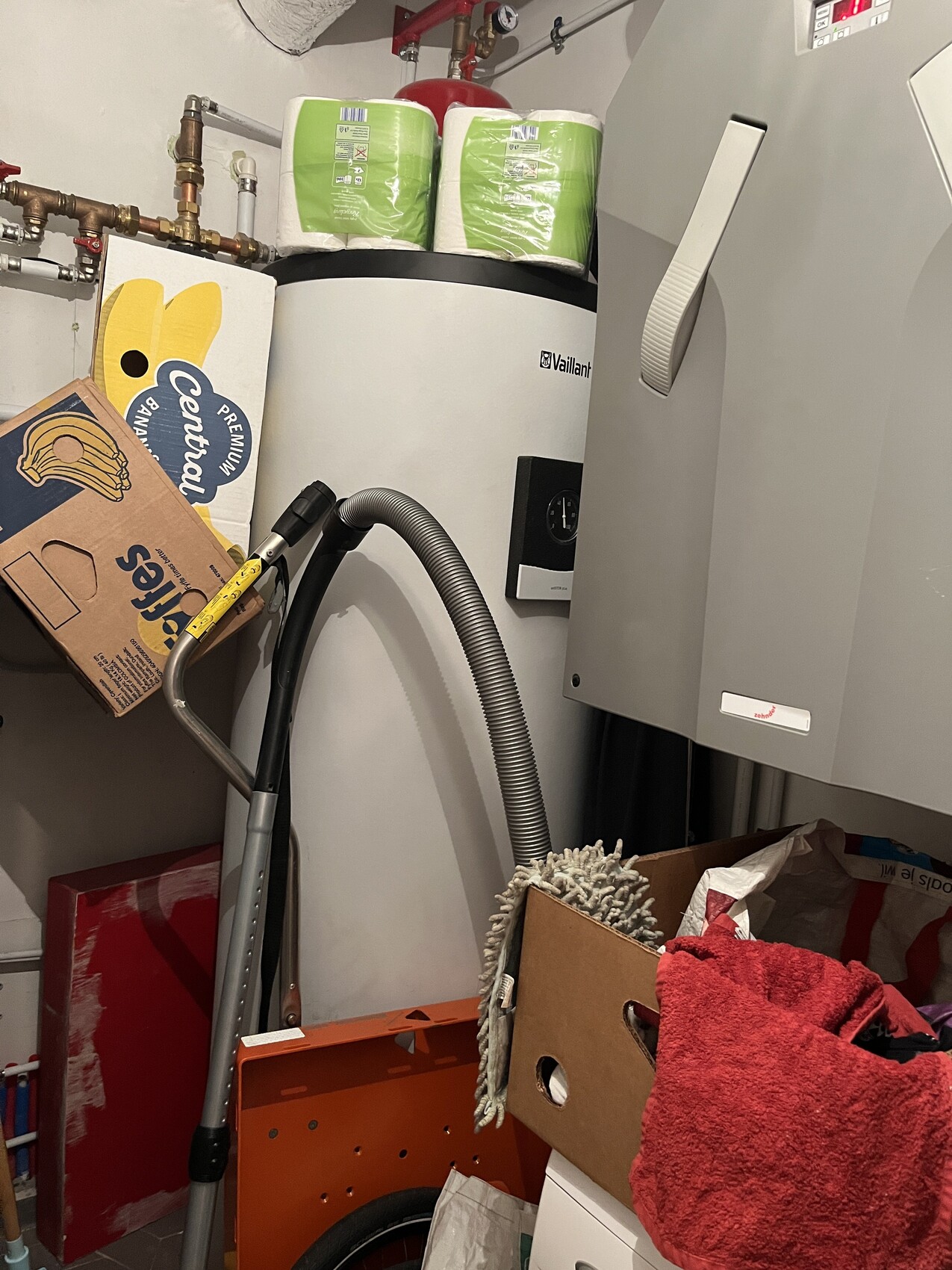 Vaillant Heizkessel im Keller, Kartons, Boxen und ein Staubsaugerrohr daneben.