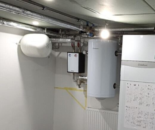 Kellerraum mit Heizkessel, Warmwasserboiler, Rohrleitungen und Heizungsanlage.