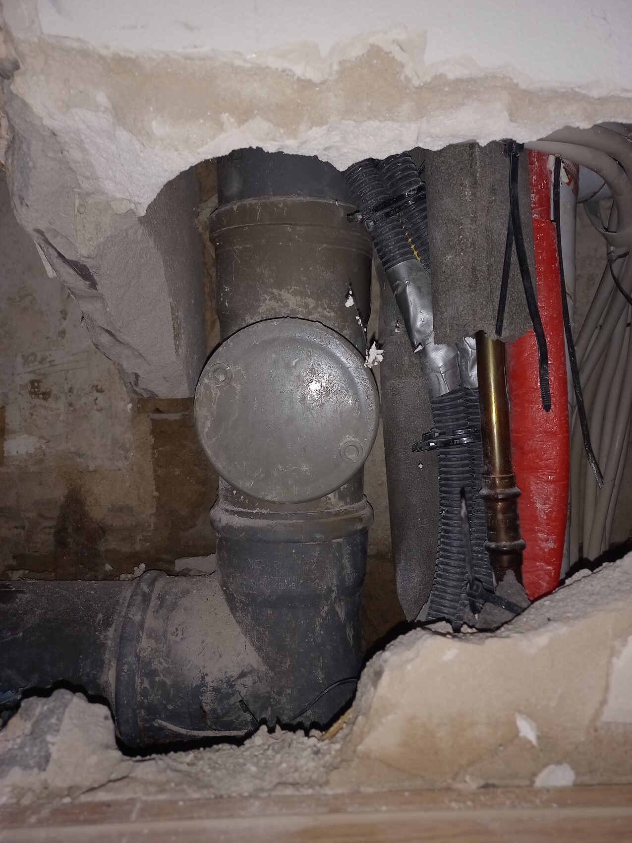 Rohre, Abflussrohre und Kabel hinter Wand im Keller