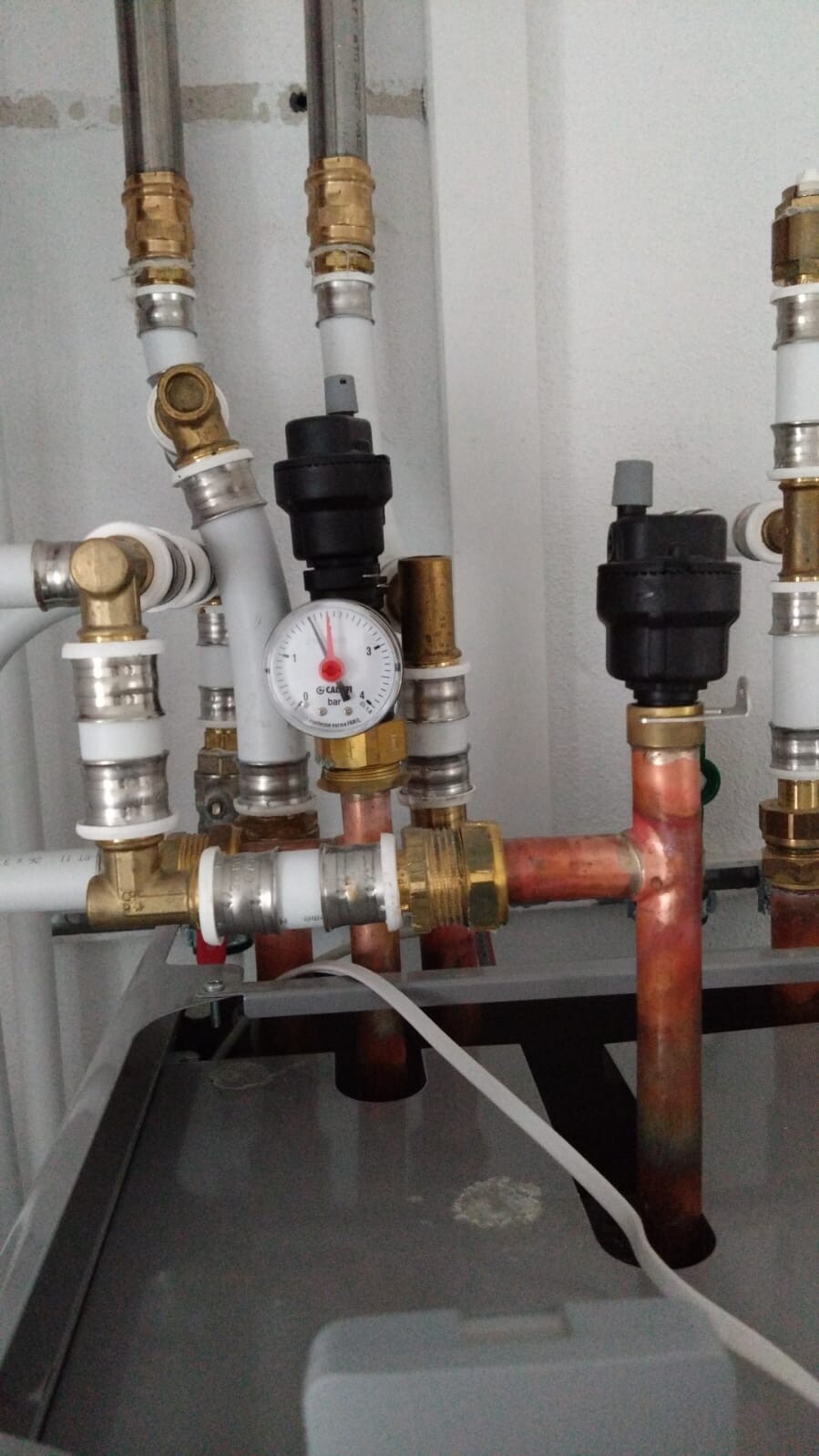 Druckmessgerät an Heizungsanlage mit Kupfer- und Kunststoffrohren, Ventilen.
