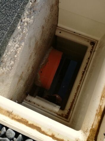 Wandöffnung mit rotem Rohrdeckel, Innenrohr und Rahmen sichtbar.