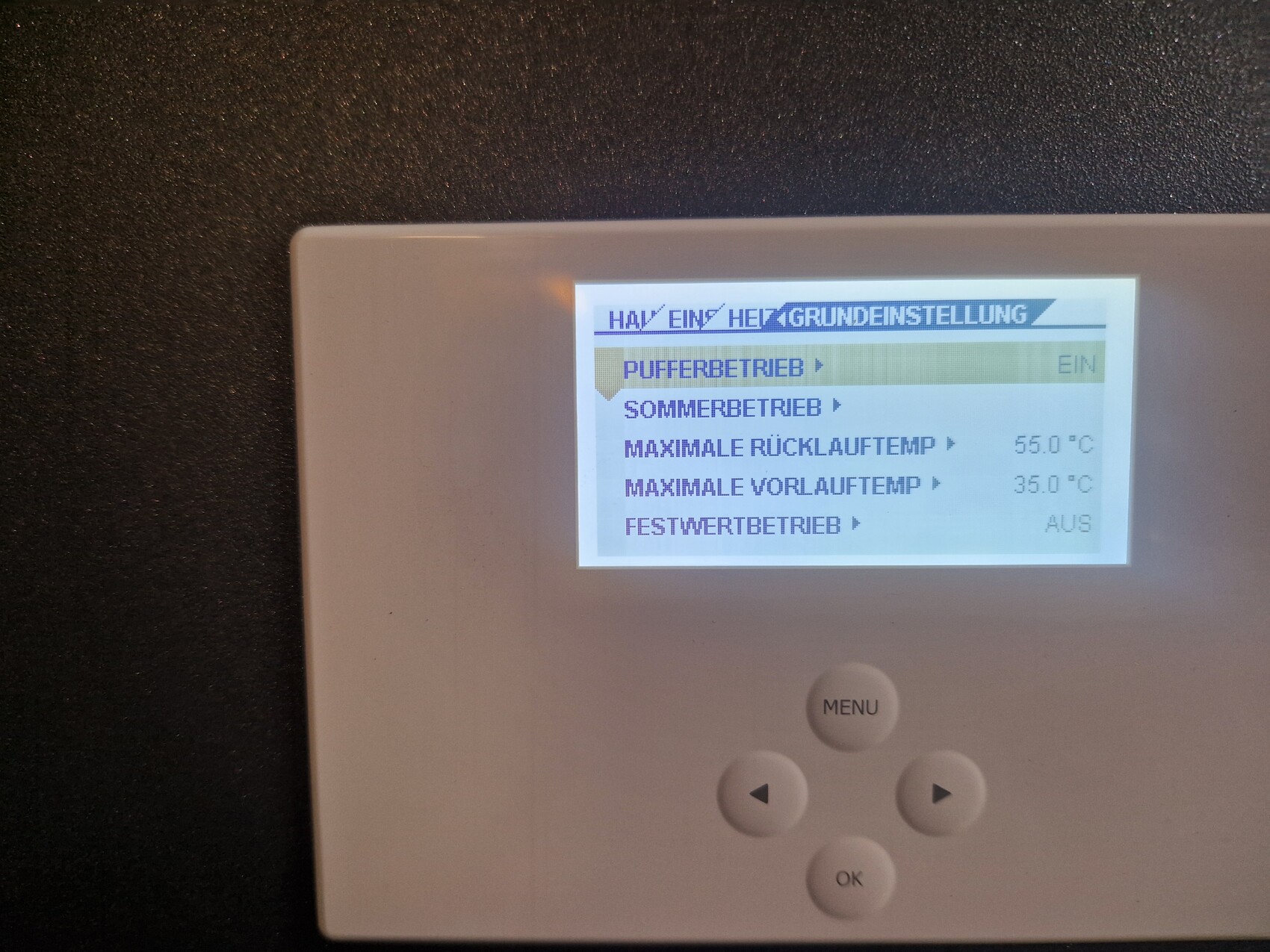 Weißes Thermostatdisplay mit Heizungsmenü und Tastensteuerung