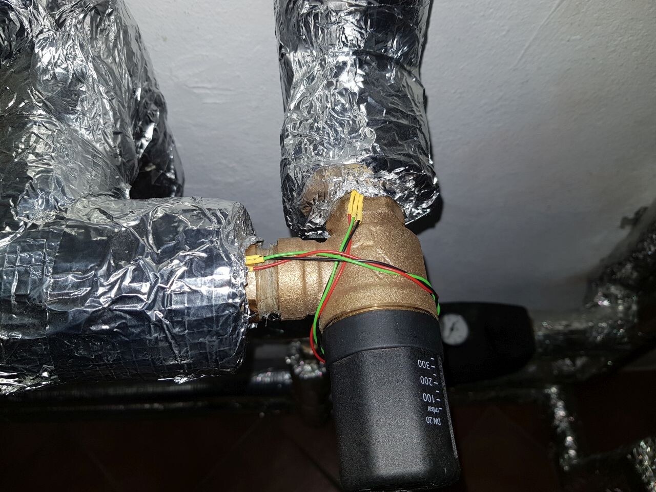 Messing-Rohrverbindung mit bunten Drähten; Aluminiumfolie-umhüllte Rohre.
