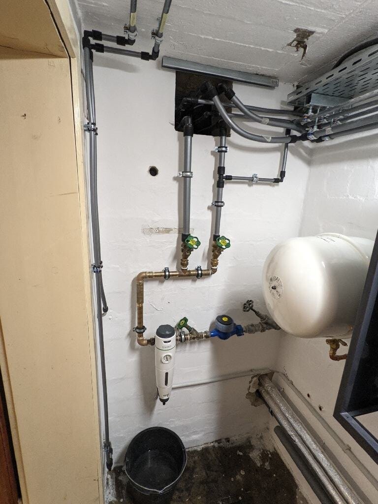 Kellerraum mit Wasserleitungsrohren, Absperrventilen, Druckregler und Ausdehnungsgefäß.