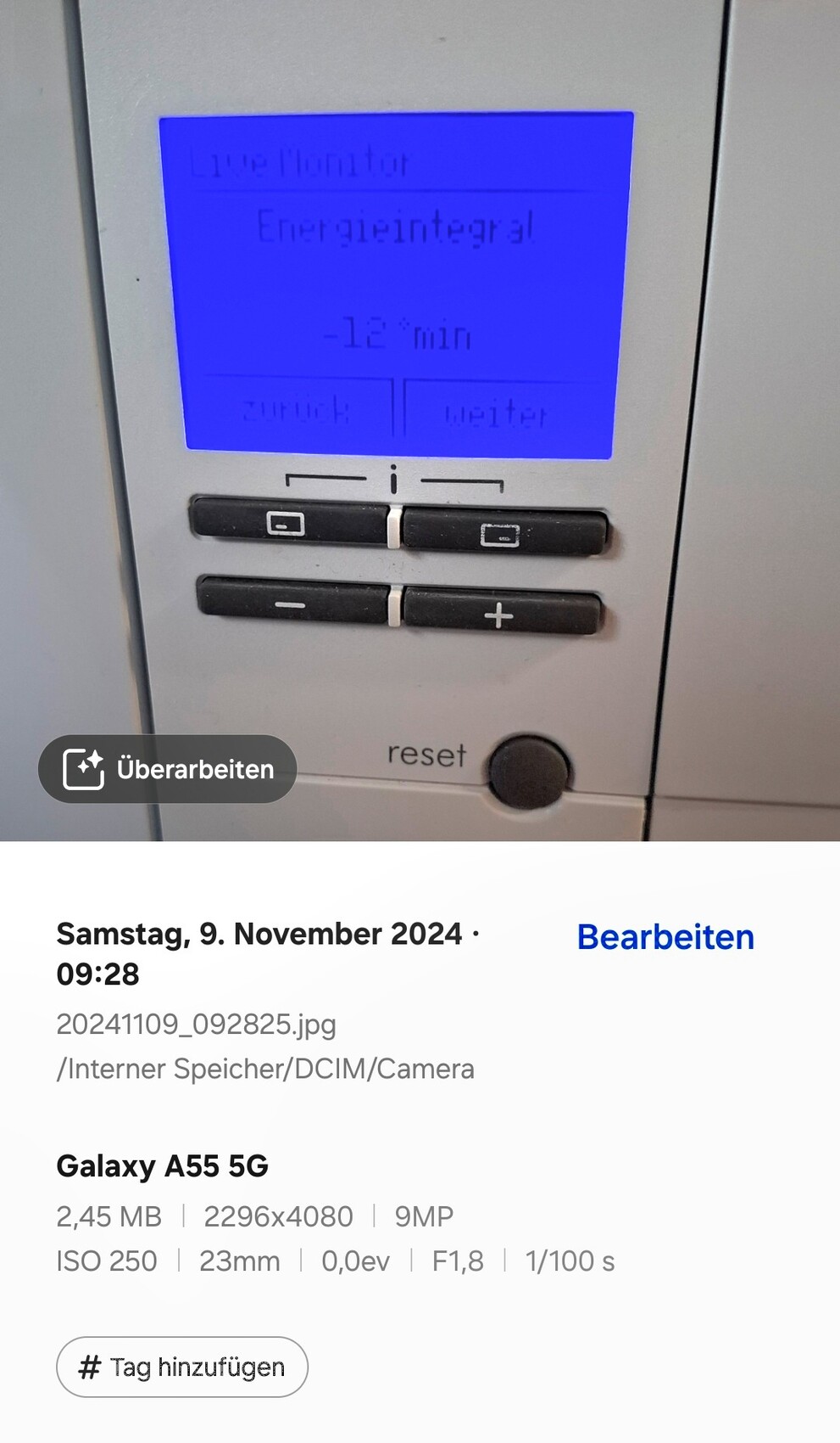 Blau beleuchtetes Display eines elektronischen Bedienfelds mit zwei Tastenreihen und Reset-Knopf.