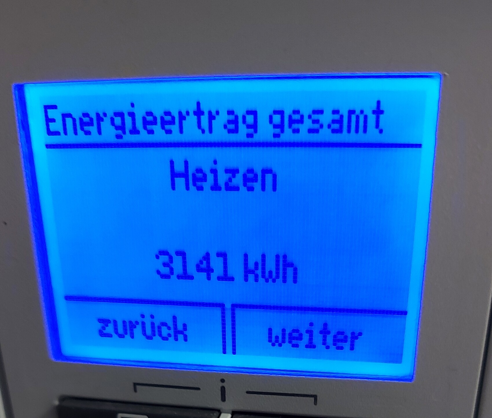 Blau beleuchtetes Display zeigt Energieverbrauch Heizen: 3141 kWh, Zurück/Weiter.