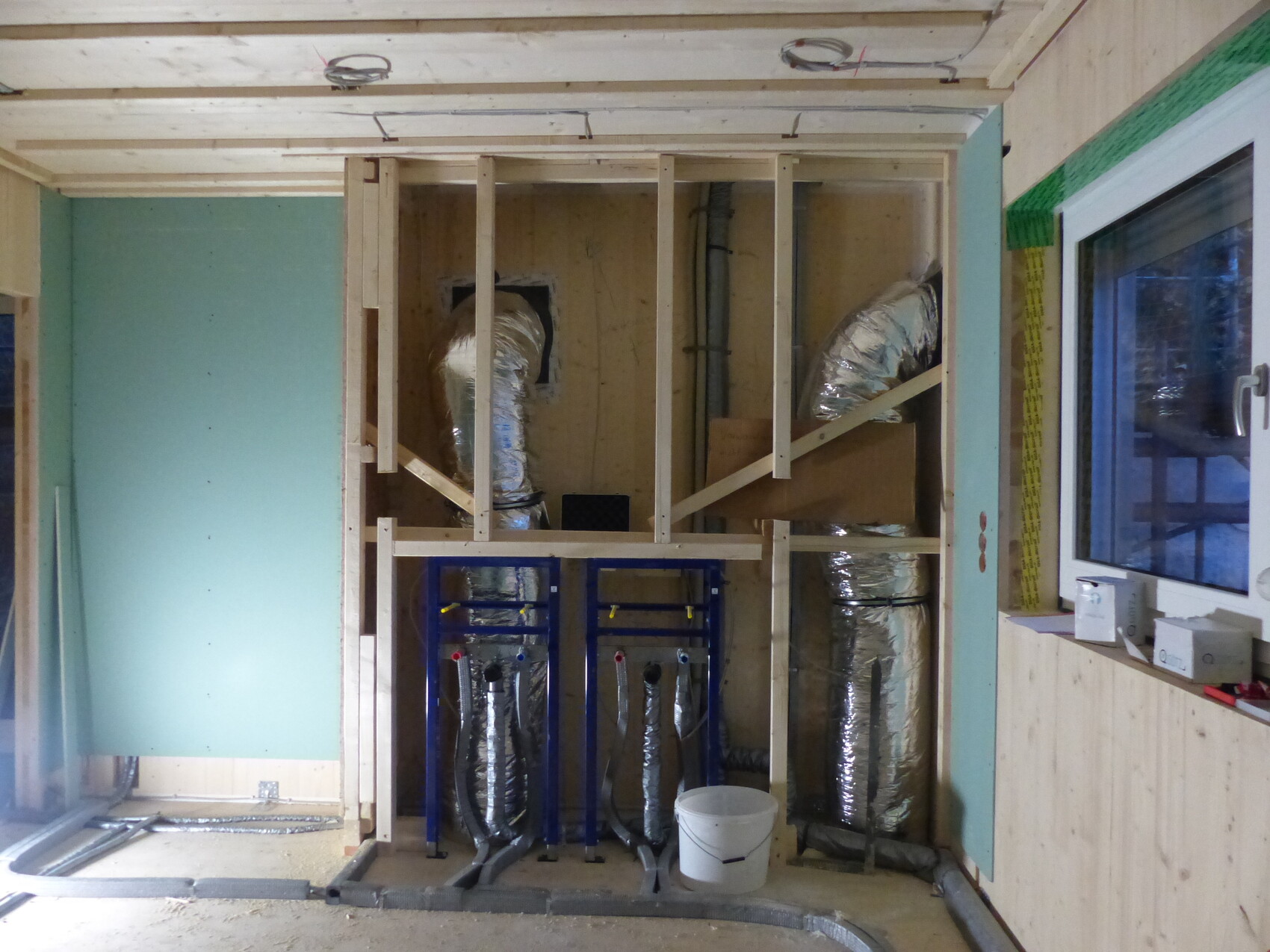Neubau Innenraum mit Holzständerwerk und installierter Haustechnik (Lüftung).