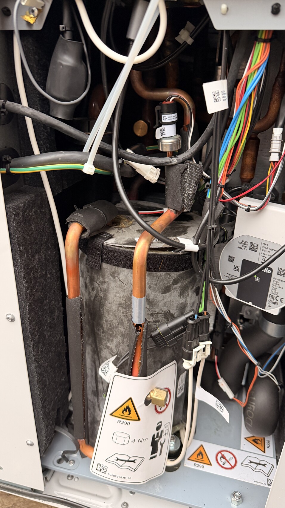 Inneneinblick in Haustechnik: Kupferrohre, Kabelbündel und Heizungsbauteile