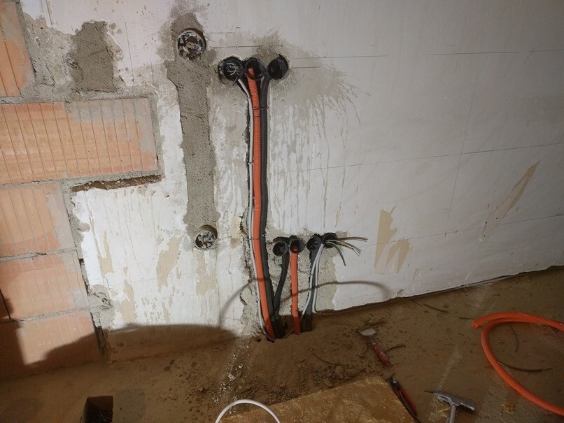 Installationen von Rohren und Kabeln in einer unfertigen Wand während des Rohbaus