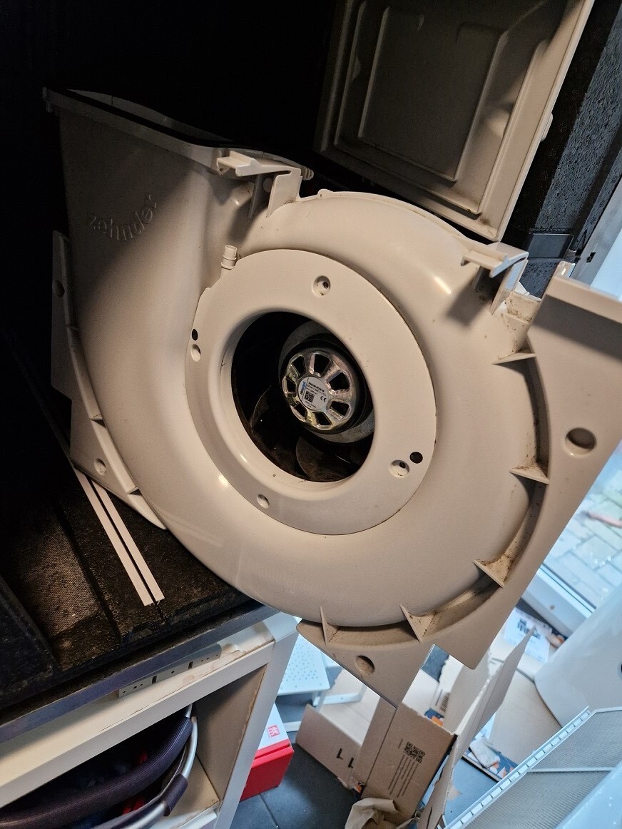 Innenansicht eines Haushaltsgeräts mit sichtbarlem Lüfterrad und Motor