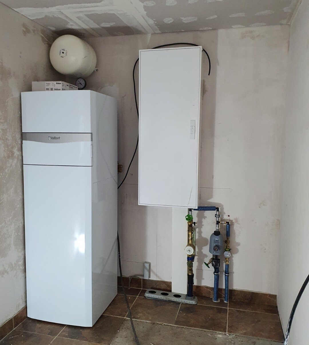 Heizungsraum mit Viessmann Heizkessel, Ausdehnungstank, Armaturen und Rohrleitungen.