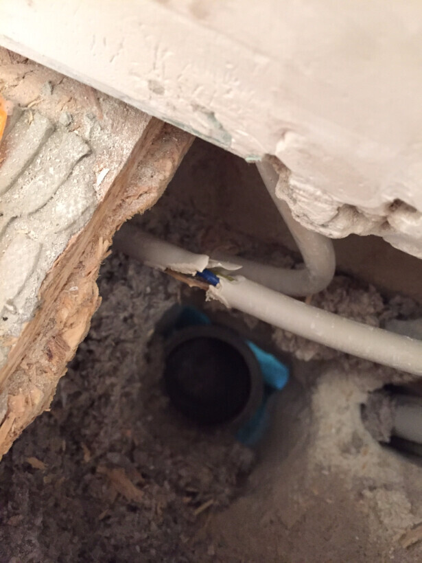 Baustelle mit Rohrleitungen in einer staubigen Wandöffnung