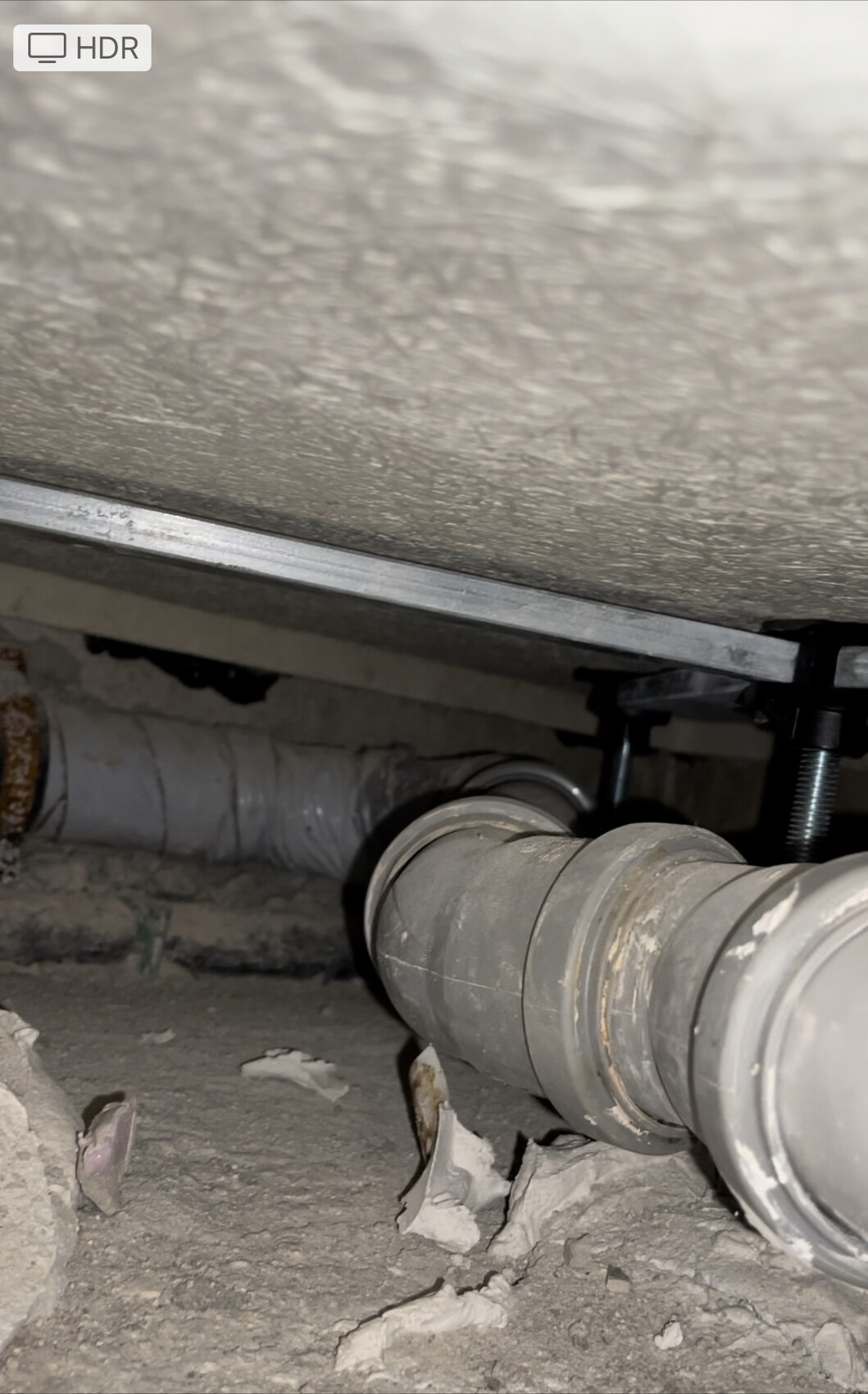 Rohrleitungen im Kellerboden mit Staub und Bauabfällen