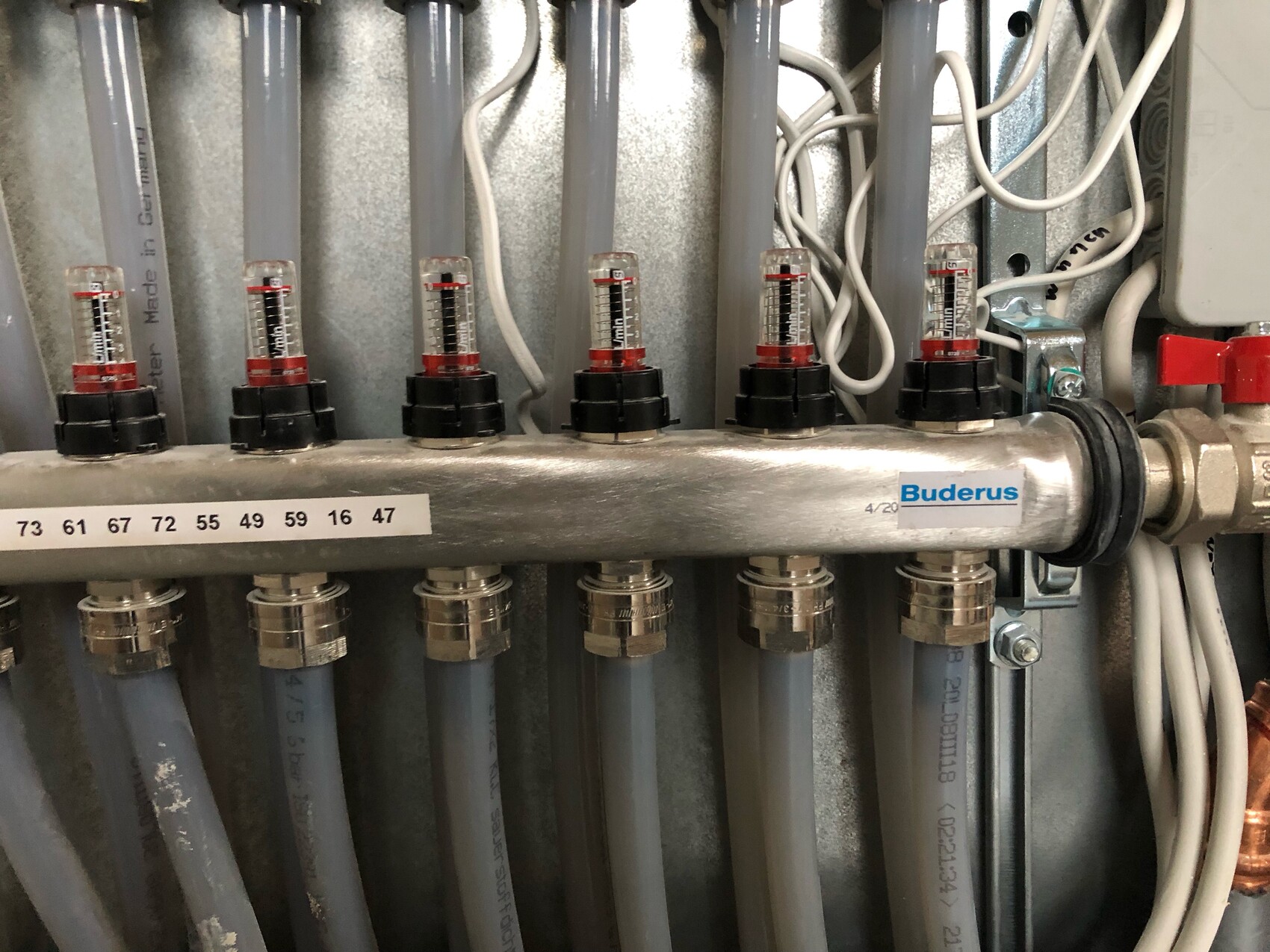Heizungs-Verteiler mit Durchflussmessern, Buderus-Logo und Kabelanschlüssen.