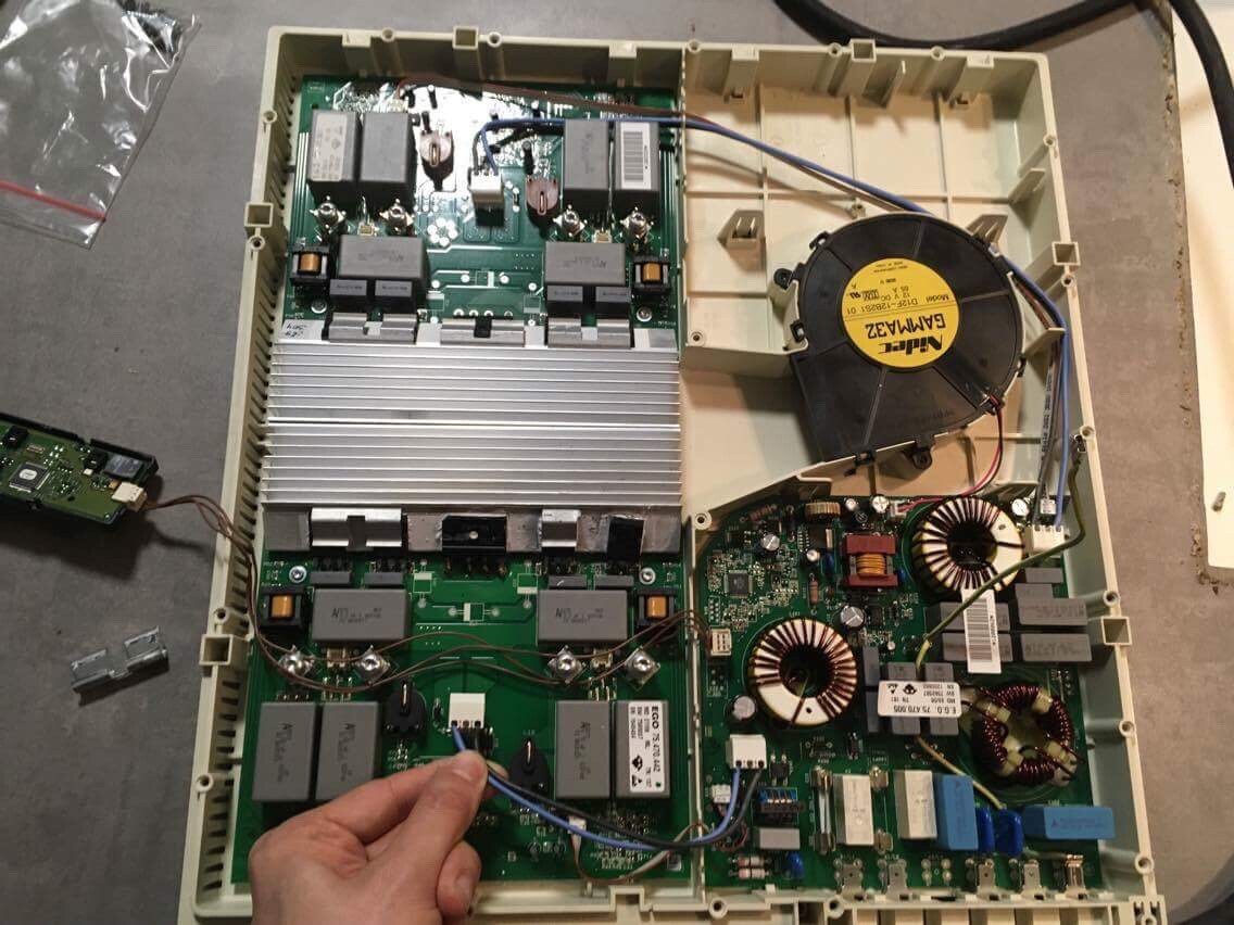 Offenes Elektroniksteuerboard mit Kühlkörper, Lüfter und Transformatoren in Haustechnikgerät