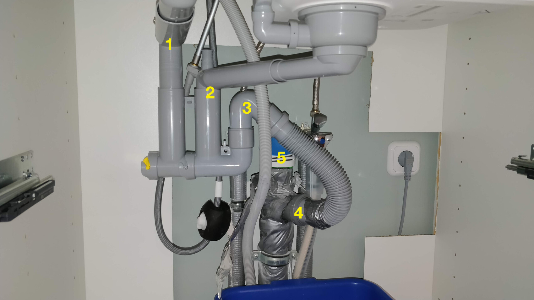 Unter dem Spülbecken sichtbare Abflussrohre, Siphon und Anschlussrohre