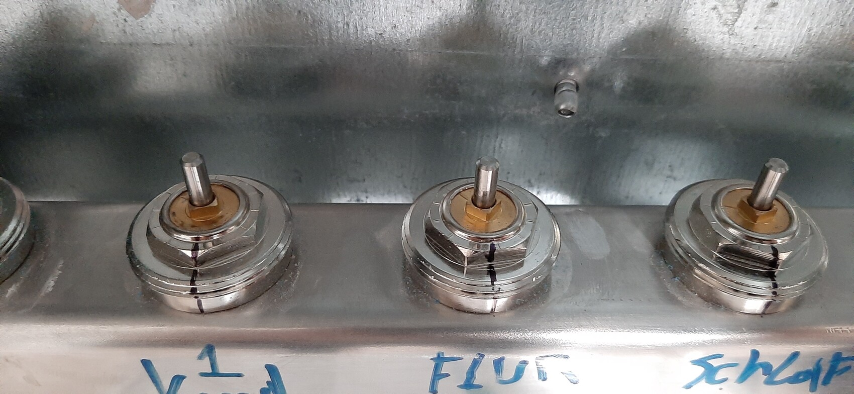 Drei Ventilbasen mit Stangen auf einer Metalloberfläche