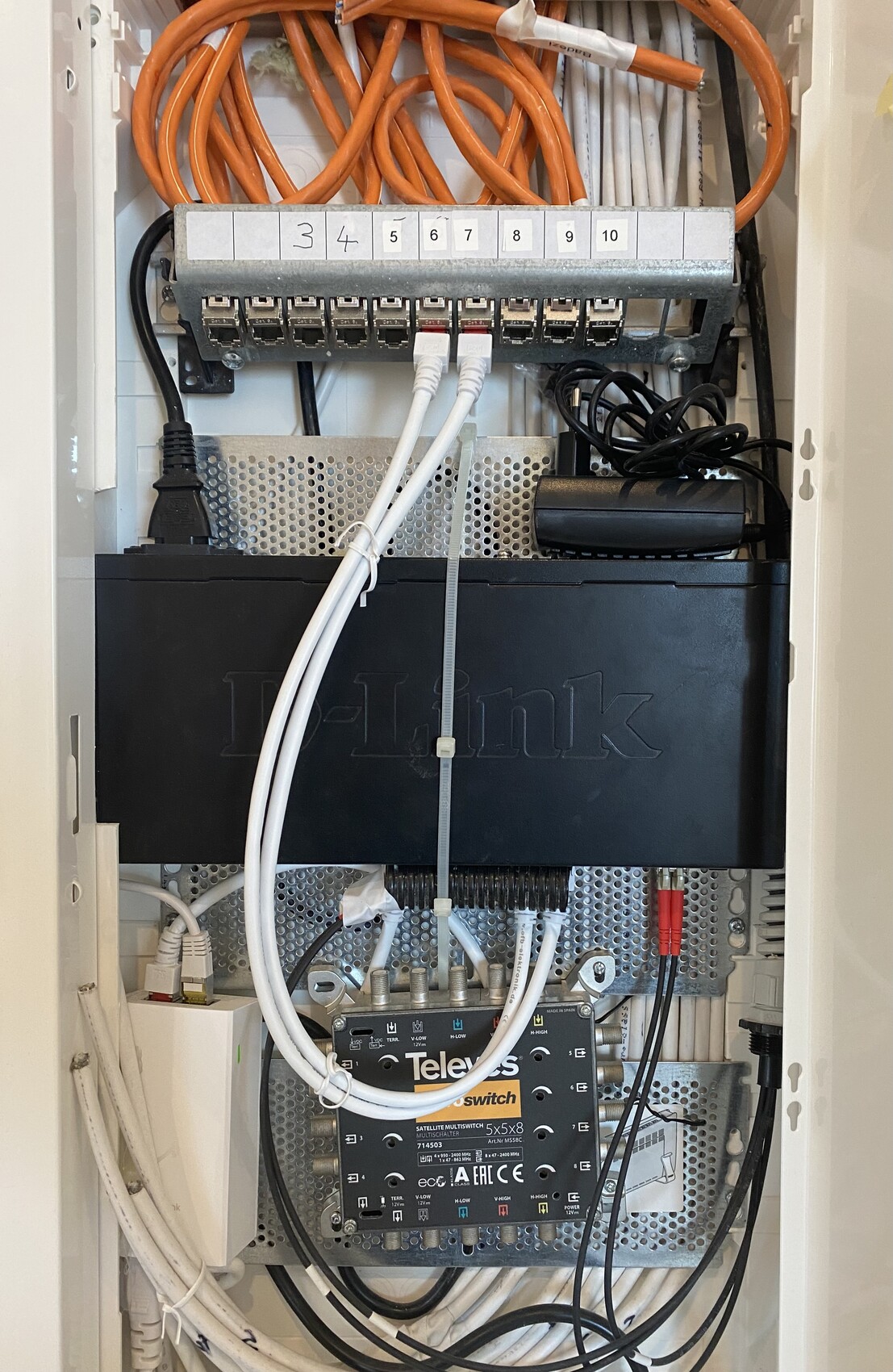 Innenansicht eines Haustechnik-Verteilerschranks mit Kabeln, Verteiler und Netzkomponenten