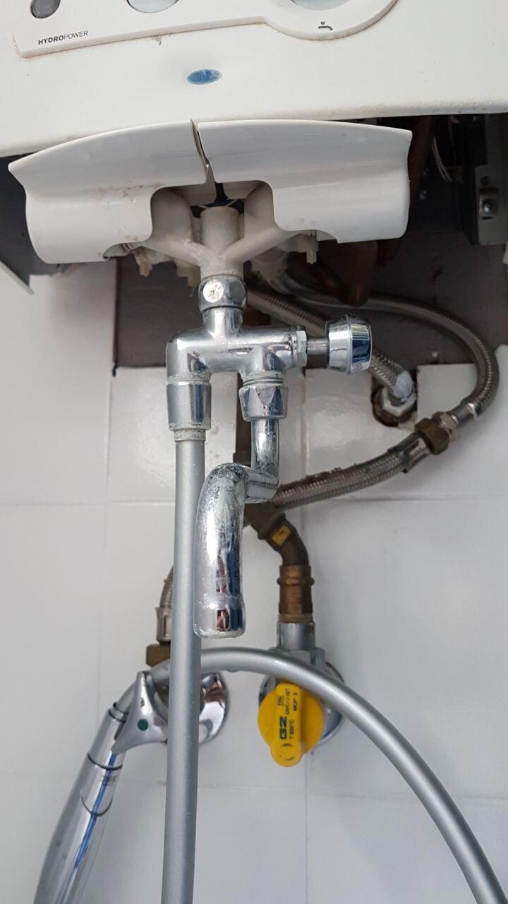 Unterbau einer Waschmaschinenversorgung mit Chromventil und flexiblen Schläuchen