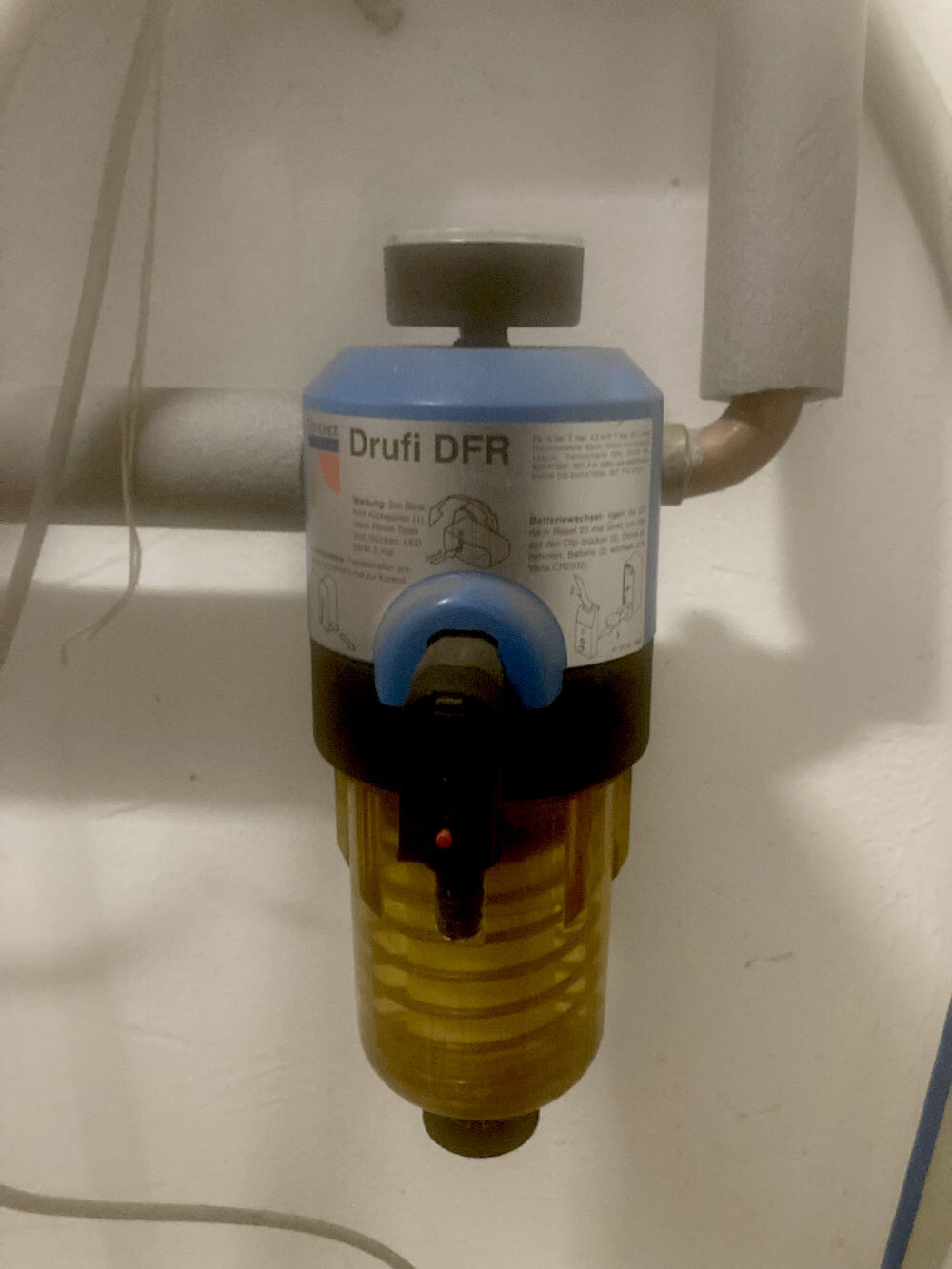 Kleiner Wasserfilter-Druckregler an Rohrverbindung unter Spüle