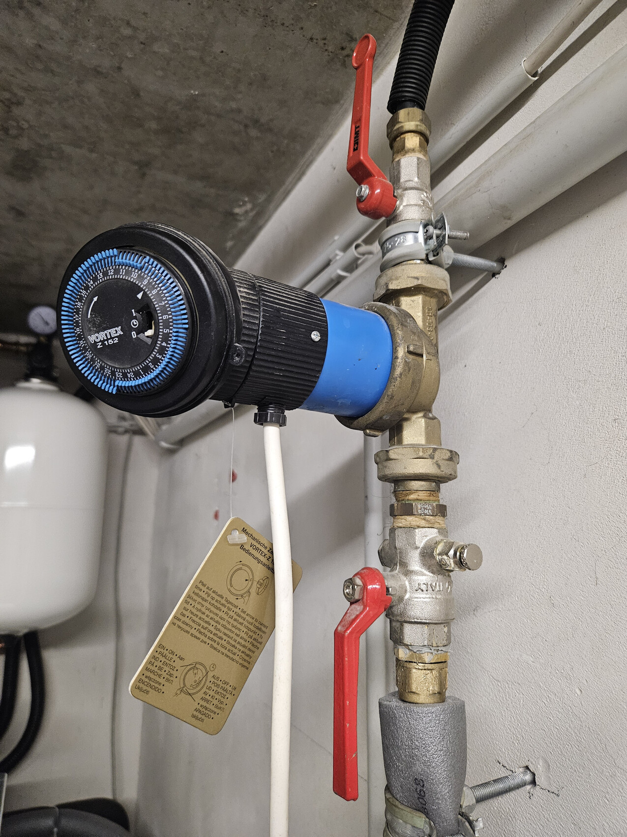 Wasserregler mit blauem Gehäuse, Druckanzeige und rotem Absperrhahn am Leitungssystem.