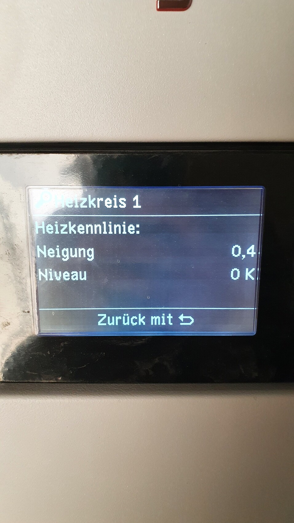 Digitales Heizungsdisplay zeigt Heizkreis 1, Neigung 0,4, Niveau 0 K, Zurück