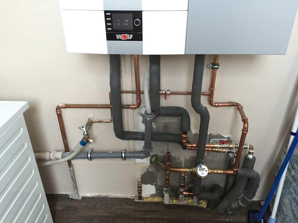 Installierte Heizungsanlage: Boiler mit Kupfer- und Isolierrohren an der Wand