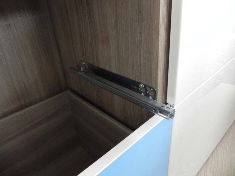 Ausgezogene Metallführung einer Schublade in einem Holzschrank, Innenraum sichtbar